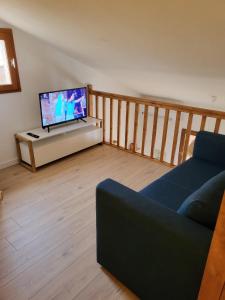 ein Wohnzimmer mit einem Sofa und einem Flachbild-TV in der Unterkunft Villa bord de mer avec belle terrasse in Port Leucate