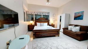 1 dormitorio con 1 cama y 1 sofá en Private rooms in 3 bedroom apartment SKYNEST Homes marina pinnacle en Dubái