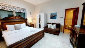 a bedroom with a large bed and a chair at Private rooms in 3 bedroom apartment SKYNEST Homes marina pinnacle in Dubai