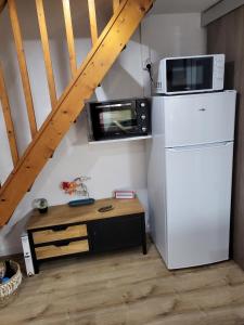 eine Küche mit einem weißen Kühlschrank und einer Mikrowelle in der Unterkunft Villa bord de mer avec belle terrasse in Port Leucate