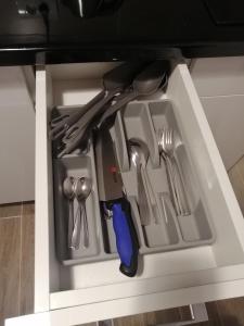 un cajón con cuchillos y utensilios en un armario en Apartmani ANTEL 5*, en Banja Koviljača