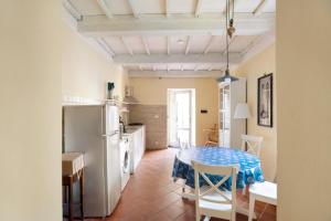 una cucina con tavolo e frigorifero di Casa Conte Picedi appartamento Luna a Lerici