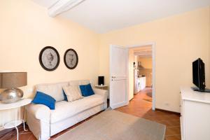 a living room with a white couch and a tv at Casa Conte Picedi appartamento Luna in Lerici