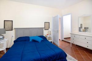 a bedroom with a blue bed and a white wall at Casa Conte Picedi appartamento Luna in Lerici