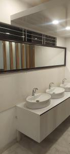 a bathroom with three sinks and a mirror at Center Point Apartment in Dhaka