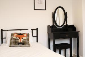 a bedroom with a bed with a mirror and a chair at Abingdon - Private Flat with Garden & Parking 02 in Cumnor