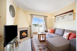 a living room with a couch and a fireplace at Casa Primavera in Carvoeiro