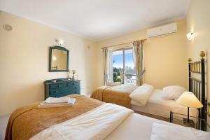 a bedroom with two beds and a mirror and a window at Casa Primavera in Carvoeiro +22 photos
