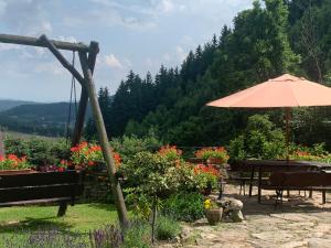 patio z parasolem, stołami i kwiatami w obiekcie Agropajda w mieście Sokolec