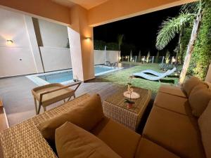 un patio con sofá, mesa y piscina en Villa golf prestigia marrakech en Marrakech