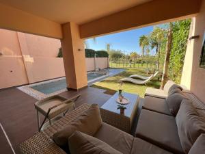 uma sala de estar com um sofá e uma mesa em Villa golf prestigia marrakech em Marrakech