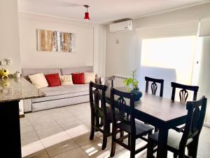 a living room with a table and chairs and a couch at Departamento céntrico, pileta cochera moderno y lujoso in Villa Carlos Paz