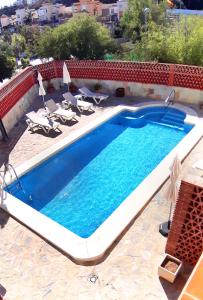 a large swimming pool with two lounge chairs and a swimming pool at Biznaga Hols in Benalmádena