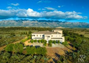 an aerial view of a house with mountains in the background at Guinevere Guest Farm in Tulbagh