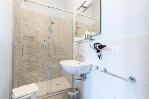 W łazience znajduje się umywalka i przeszklony prysznic. w obiekcie Albergo Centrale w Sienie