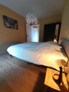 1 dormitorio con 1 cama grande y edredón blanco en Le gîte du Parc, en Villers-devant-Orval