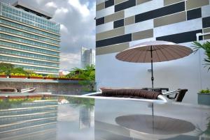 a table with an umbrella next to a building at Diagonal Hotel Chipichape in Cali