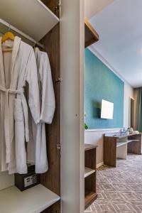 La salle de bains est pourvue d'un placard avec des vêtements blancs. dans l'établissement ALBA HOTEL & SPA, à Baku