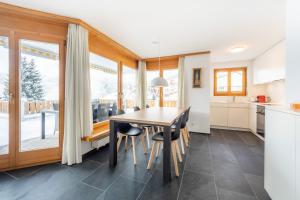 a kitchen and dining room with a wooden table and chairs at Casa Guarda Val 1 in Falera