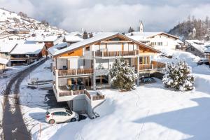 une maison dans la neige avec une voiture dans l'établissement Casa Guarda Val 1, à Falera