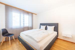 - une chambre avec un lit et une chaise dans l'établissement Casa Guarda Val 1, à Falera