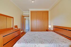 Un dormitorio con una cama grande y armarios de madera. en Lagos Balcony With Pool by Homing, en Lagos 12 fotos más
