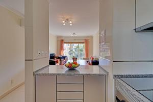 una cocina con una barra con un bol de fruta. en Lagos Balcony With Pool by Homing, en Lagos