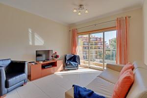 Una sala de estar con un sofá y un televisor. en Lagos Balcony With Pool by Homing, en Lagos