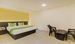 Schlafzimmer mit einem Bett, einem Schreibtisch und einem Stuhl in der Unterkunft Treebo Trend Raaya Regency in Mahabaleshwar