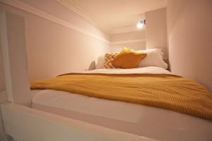 a bedroom with a bed with a yellow blanket at Lovely 1 Bed serviced apartment in Cambridgeshire in Ely
