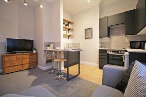 una cocina con mesa y TV. en Lovely 1 Bed serviced apartment in Cambridgeshire en Ely