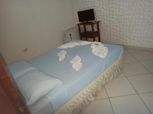 a bedroom with a bed with white flowers on it at Pousada Canto Juquehy in Juquei