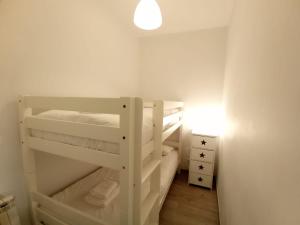 a small room with white bunk beds with a light at Cozy in Malasaña in Madrid