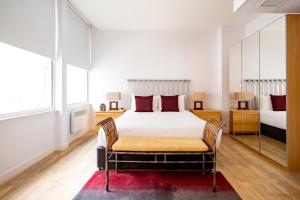 una camera con un grande letto e uno specchio di 196 Bishopsgate a Londra