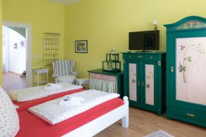 a bedroom with two beds and a flat screen tv at Pension Villa Immergrün in Oberhof