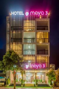 a hotel with a neon sign on the side of it at Maya Hotel 3 in Con Dao