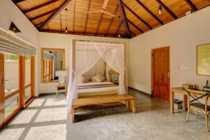 a bedroom with a bed with a canopy at The Spice Trail in Arugam Bay
