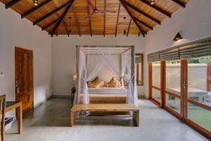 a bedroom with a bed with a mosquito net at The Spice Trail in Arugam Bay