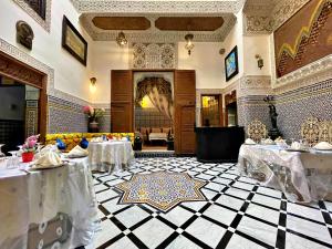 a restaurant with two tables with white table cloth at Riad Dar Guennoun in Fez