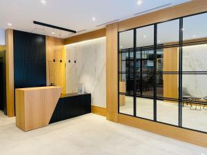 una oficina con una gran puerta de cristal y un escritorio en Hotel Alcántara, en Cáceres