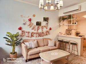 a living room with a couch and a happy birthday sign at 小院子4人至6人包棟民宿 in Taitung City