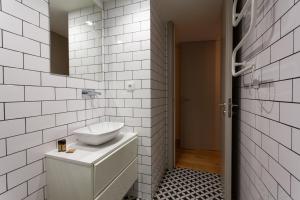 une salle de bain blanche avec un lavabo et un miroir dans l'établissement Oporto City View- Trindade Lovely, à Porto 52 autres photos