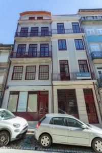 zwei vor einem Gebäude geparkt in der Unterkunft Oporto City View- Trindade luxury in Porto