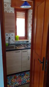 a kitchen with a sink and a stove and a window at Appartamento del sole in Bardonecchia