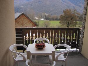 einen Tisch und Stühle auf einem Balkon mit Aussicht in der Unterkunft Le Paradis d'ARAN in Luchon