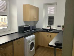 a kitchen with a washing machine and a microwave at 4 Stills Apartment in Rothes