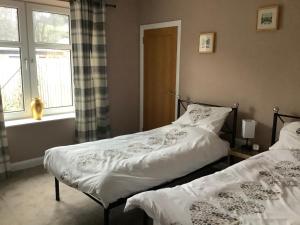 two beds sitting next to each other in a bedroom at 4 Stills Apartment in Rothes