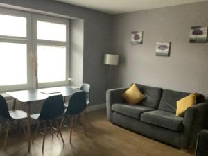 a living room with a couch and a table at 4 Stills Apartment in Rothes