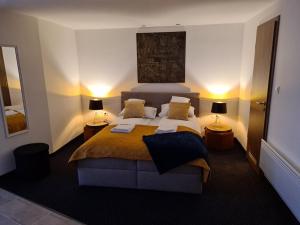 a bedroom with a large bed with two lamps at City Center Apartmanház in Eger