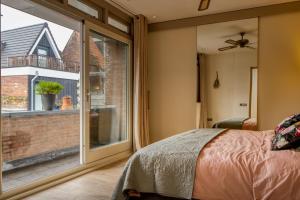 a bedroom with a large window and a bed at Gunnery's Guest House in Alkmaar